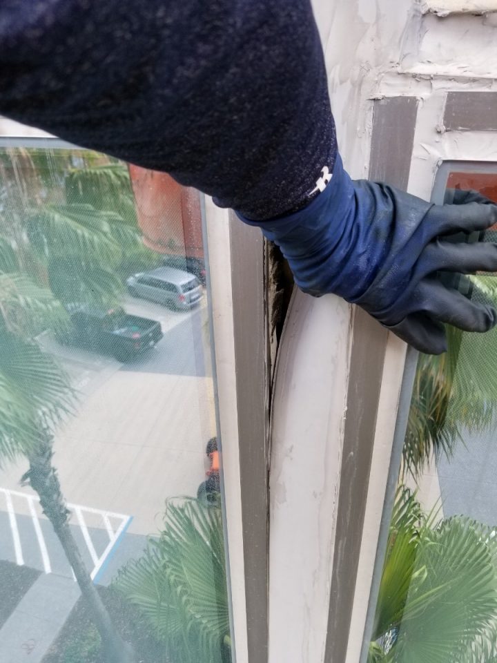 Presto technician inspecting failed caulking on office building
