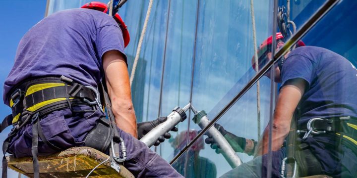 caulking-specialist-applying-caulking-to-building Caulking specialist applying caulking to window frame