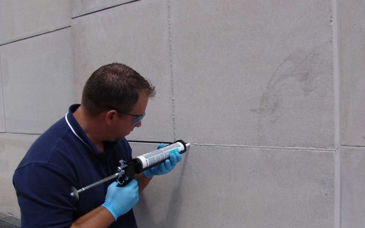 a presto technician caulking the exterior of a commercial building