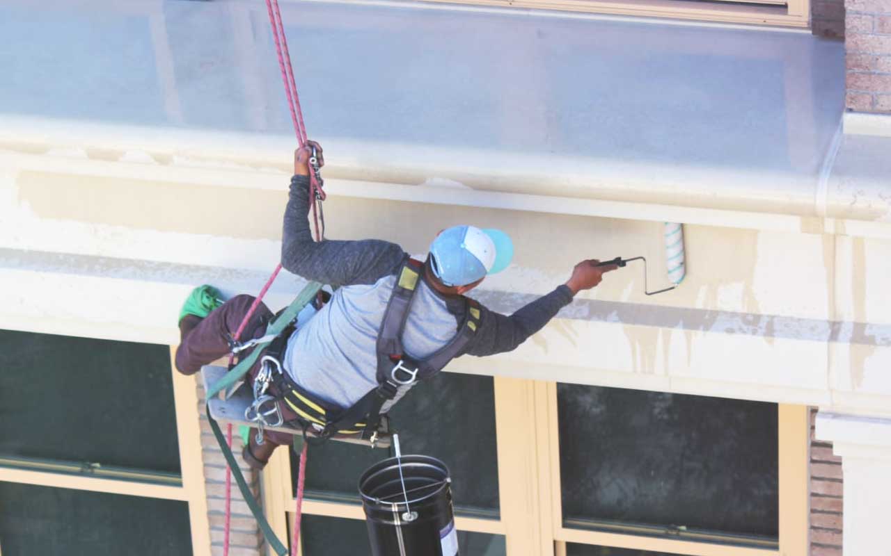 Waterproofing Expert Applying Coating to Exterior of Commercial Building