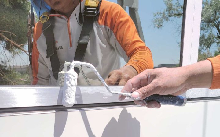 adding a protective coating to metal window frame on a newly built commercial building